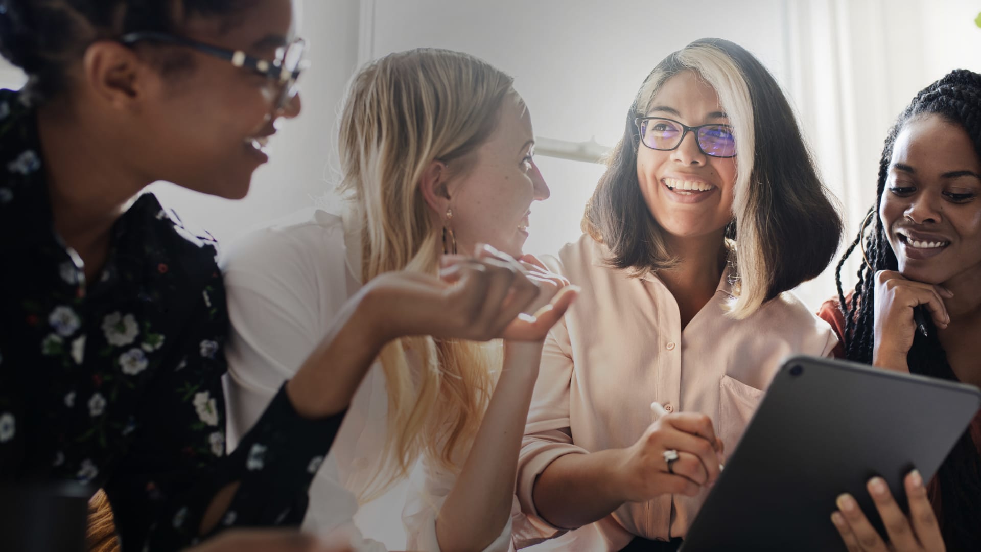 Women talking while holding iPad