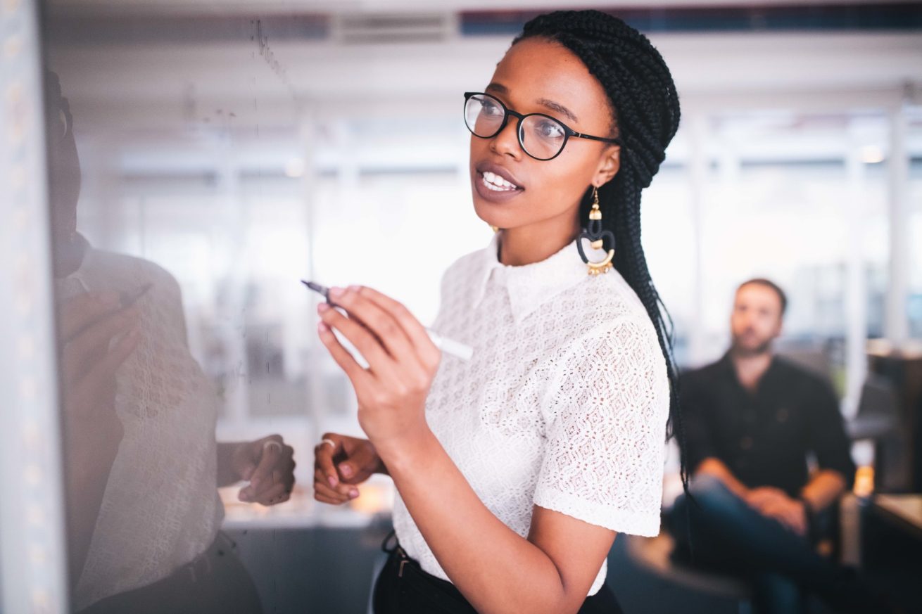 Woman writing on white board